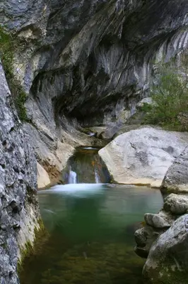a river with a waterfall in a rocky canyon at APARTMA KMETIJA ROVAN in Vrhpolje