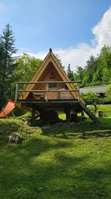 a large wooden house sitting on top of a grass field at U KONC in Stahovica