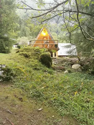 a cabin in the woods with a light on it at U KONC in Stahovica