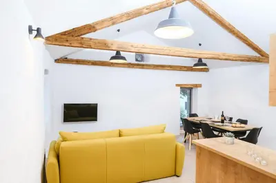 a living room with a yellow couch and a table at Roner Resort in Plavje