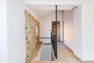 a staircase in a house with a stone wall at Roner Resort in Plavje