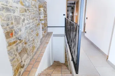 a staircase with a stone wall and a black railing at Roner Resort in Plavje