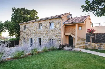 a stone house with a garden in front of it at Roner Resort in Plavje
