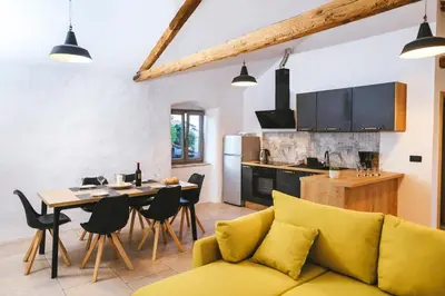 a living room and kitchen with a yellow couch and a table at Roner Resort in Plavje