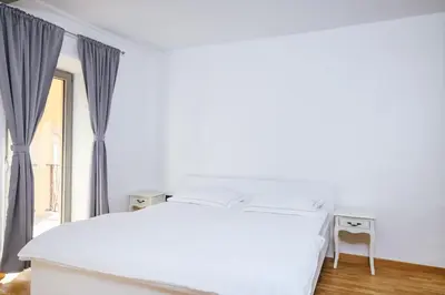 a white bed in a room with a window at Roner Resort in Plavje