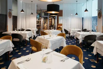 a dining room with tables and chairs with white tablecloths at Spa Suite Dobrna - Terme Dobrna in Dobrna