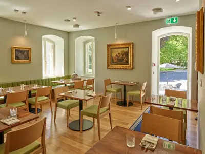 a dining room with wooden tables and chairs at Spa Suite Dobrna - Terme Dobrna in Dobrna