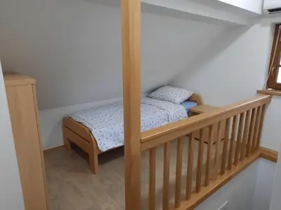 a small bed in a room with a crib at Vineyard cottage Klobčar in Semič
