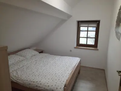 a bedroom with a bed and a window at Vineyard cottage Klobčar in Semič