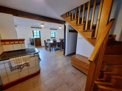 a kitchen and dining room with a staircase in a house at Vineyard cottage Klobčar in Semič