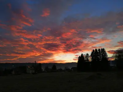 a sunset in a field with trees and clouds at Freya in Lesce