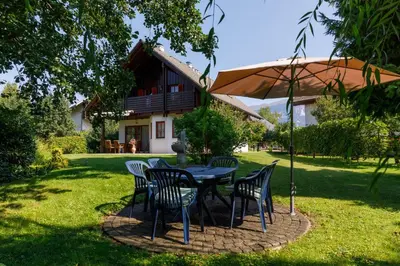 a table with chairs and an umbrella in a yard at Villa Toni in Bled
