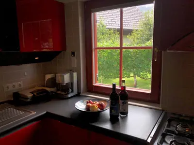 a kitchen counter with bottles and a bowl of fruit and a window at Villa Toni in Bled