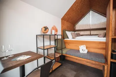 a small room with a bed and a desk at Nesting Resort - Homestead SONČNI RAJ in Maribor