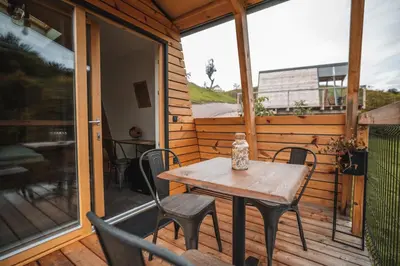 a wooden table and chairs on a screened in porch at Nesting Resort - Homestead SONČNI RAJ in Maribor