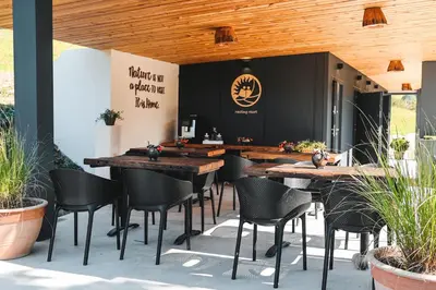 a restaurant with wooden ceilings and tables and chairs at Nesting Resort - Homestead SONČNI RAJ in Maribor