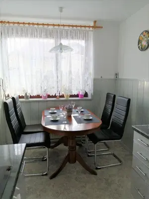 a dining room table with four chairs and a window at Apartma TIA in Bled