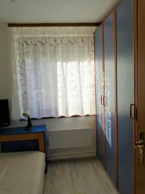 a bedroom with a bed and a window with a curtain at Apartma TIA in Bled