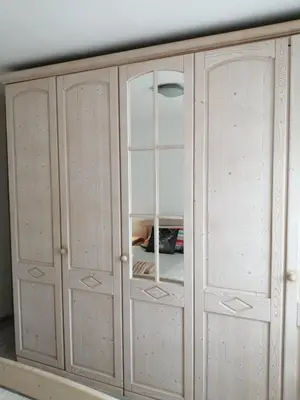 a wooden cabinet with glass doors in a room at Apartma TIA in Bled