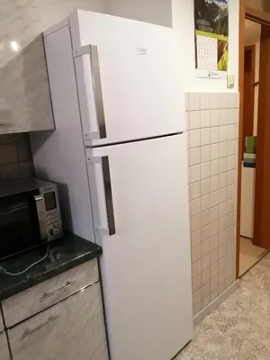 a white refrigerator in a kitchen with a microwave at Apartma TIA in Bled