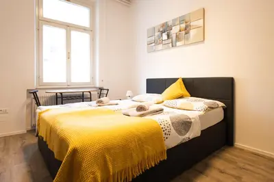a bedroom with two beds with yellow sheets at Epicenter - rooms & terrace in Ljubljana