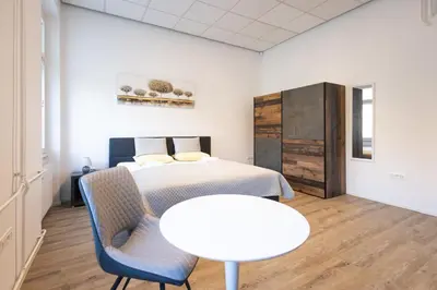 a bedroom with a bed and a table and chairs at Epicenter - rooms & terrace in Ljubljana