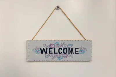 a sign with the word welcome hanging on a wall at Epicenter - rooms & terrace in Ljubljana