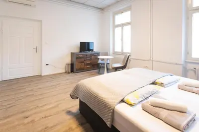 a bedroom with a bed and a desk with a tv at Epicenter - rooms & terrace in Ljubljana
