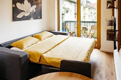 a large bed in a room with a balcony at Woody - comfy apartment in Šiška in Ljubljana