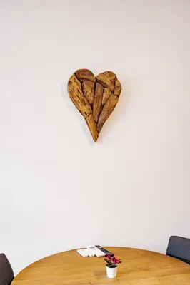 a heart on a wall above a wooden table at Woody - comfy apartment in Šiška in Ljubljana