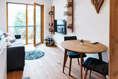 a small living room with a table and chairs at Woody - comfy apartment in Šiška in Ljubljana