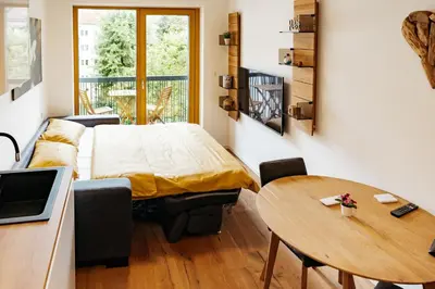 a small room with a bed and a table at Woody - comfy apartment in Šiška in Ljubljana
