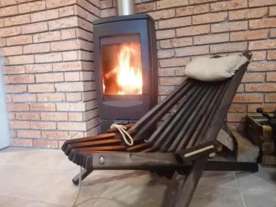 a wooden bench in front of a fireplace at Rogla - Apartma ROŽLE in Vitanje