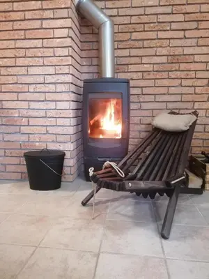a bench with a fireplace in a brick wall at Rogla - Apartma ROŽLE in Vitanje