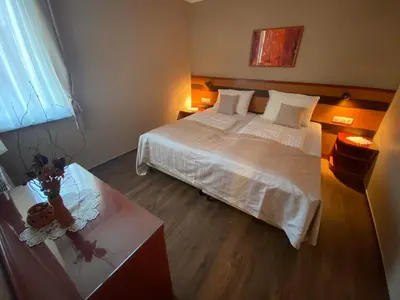 a bedroom with a large white bed and a table at Udoben apartma v Moravskih Toplicah in Moravske Toplice