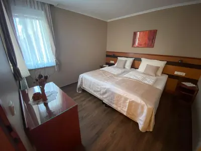 a bedroom with a large bed and a glass table at Udoben apartma v Moravskih Toplicah in Moravske Toplice