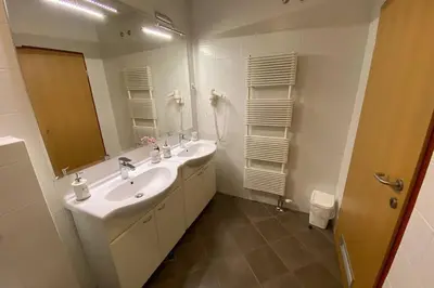 a bathroom with two sinks and a large mirror at Udoben apartma v Moravskih Toplicah in Moravske Toplice