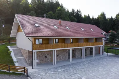 a building with a red roof on top of it at Apartmaji Hočka Koča in Pohorje