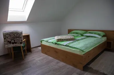 a bedroom with a bed and a chair and a skylight at Apartmaji Hočka Koča in Pohorje