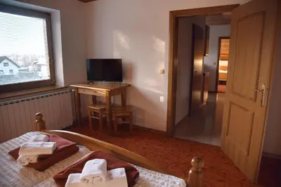a bedroom with a bed and a television and a window at Rooms and Apartments Panker in Moravske Toplice