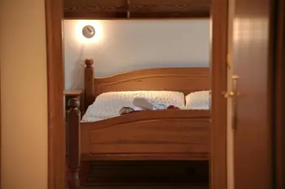 a bedroom with a bed with a wooden headboard at Rooms and Apartments Panker in Moravske Toplice
