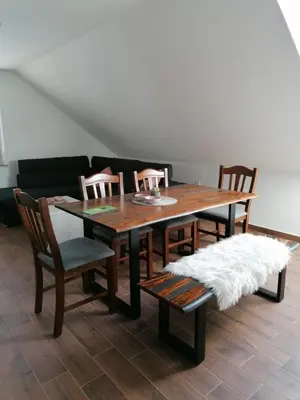 a dining room table with four chairs and a couch at BLATNIKOV HRAM in Dvor