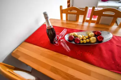 a bottle of wine and a plate of fruit on a table at City Centre Lux in Maribor