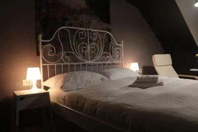 a bedroom with a large white bed with two lamps at Hostel Sleeping Beauty in Ljubljana