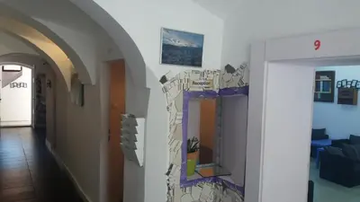 a hallway with a wall with a painting on it at Hostel Sleeping Beauty in Ljubljana