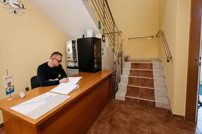 a man sitting at a counter in a room at Hotel Murat in Ptuj