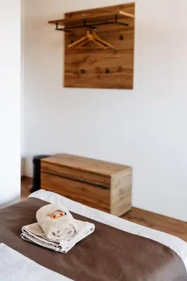 a bed with a towel and a dresser in a room at Hotel Murat in Ptuj