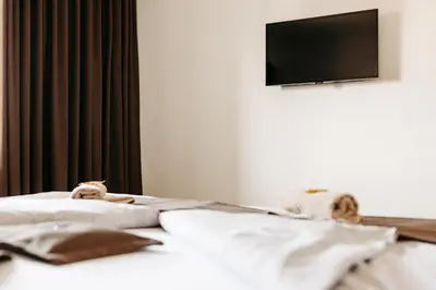 two stuffed animals sitting on a bed with a television at Hotel Murat in Ptuj