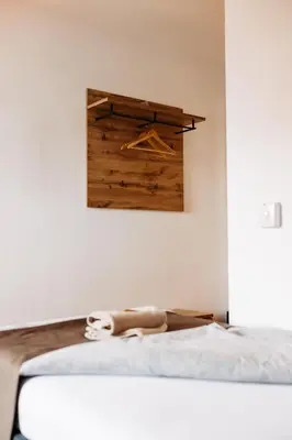 a bedroom with a bed and a wooden wall at Hotel Murat in Ptuj