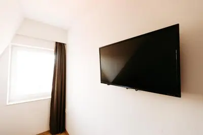 a flat screen tv hanging on a wall next to a window at Hotel Murat in Ptuj